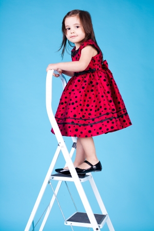 little girl on the stairs  Studio shot on a white background の写真素材