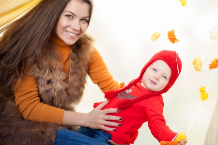 Happy mother and her baby posing sitting in tent outdoor の写真素材
