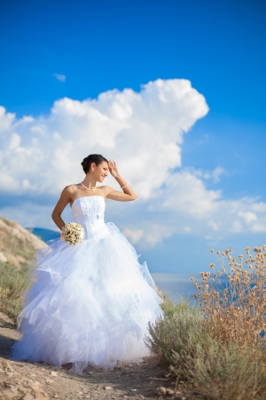 wedding  bride on cliff against the blue seaの写真素材