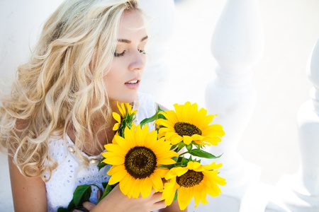 Close-up portrait of attractive woman with sunflowers in her handの写真素材
