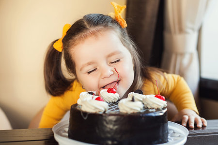 happy little girl indoors with a birthday cake