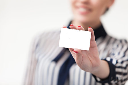 Smiling businesswoman showing and handing a blank business card
