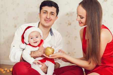 Portrait of happy family with cute baby in suit of Santa's little helperの写真素材