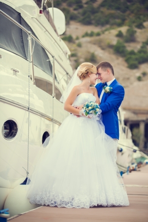 Beautiful bride and groom wedding couple near sea yachtの写真素材