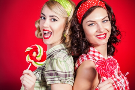 Beautiful pinup girls with lollipop on red backgroundの写真素材