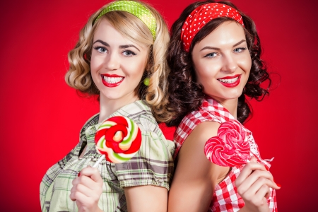 Beautiful pinup girls with lollipop on red backgroundの写真素材