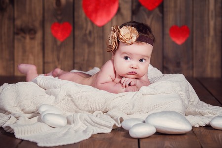 Sweet little baby girl crawling on a wooden floorの写真素材