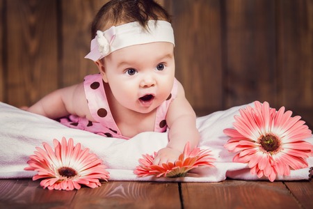 Sweet little baby girl crawling on a wooden floorの写真素材