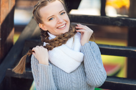 Portrait of lovely young female sitting on steps and smiling