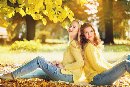 Two young girl in autumn forestの写真素材