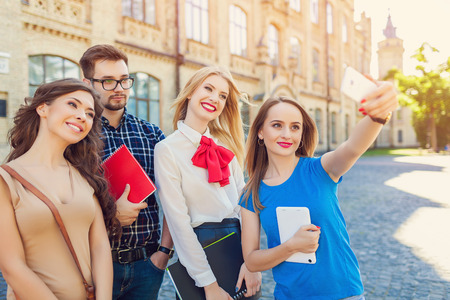 Shot of college students hanging out on campus. Happy classmatesの写真素材