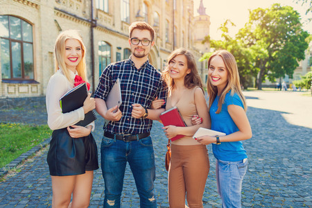 Shot of college students hanging out on campus. Happy classmatesの写真素材