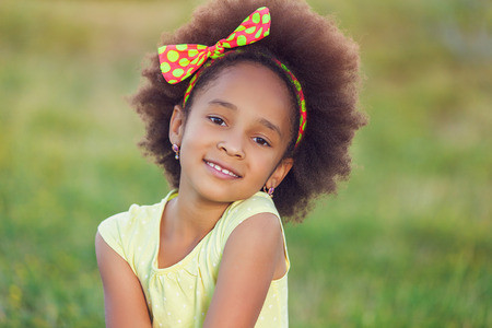Outdoor portrait of pretty mixed race African-American girl smiling outdoorの写真素材