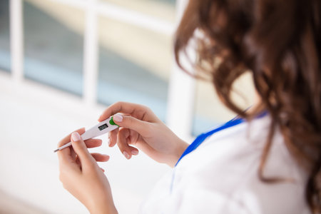 Portrait of a friendly doctor with thermometer