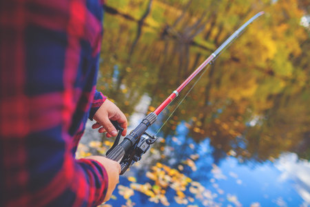 Hands of Man fishing with rod. River on backgroundの写真素材