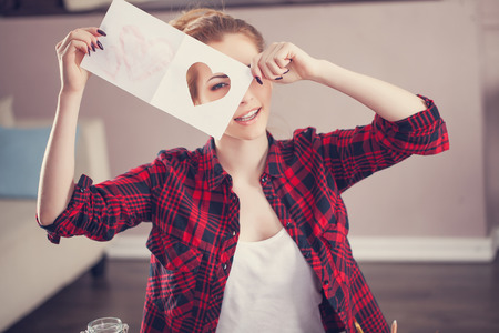 Woman creating gift at home with paper and gouacheの写真素材