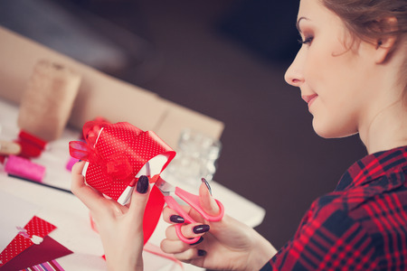 Woman creating gift at home with paper and gouacheの写真素材