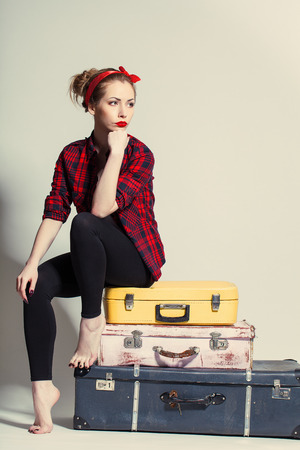 woman sits on retro suitcasesの写真素材