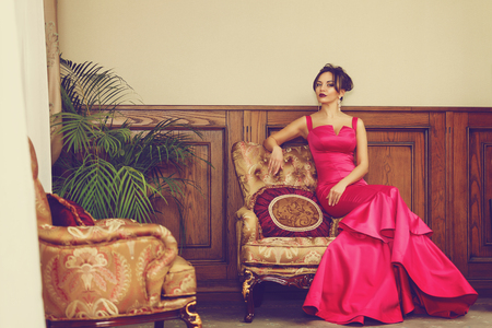 Elegant young woman in evening dress posing in luxury interior. Fashion shotの写真素材