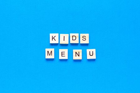 kids menu inscription in wooden letters on a blue background, flat layout, top viewの写真素材