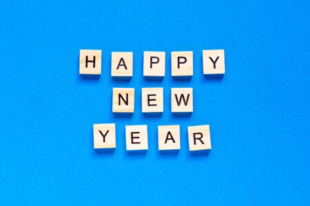 Happy New year written in wooden letters on a blue background. Happy new year 2021. top view. flat layout. space for text.の写真素材