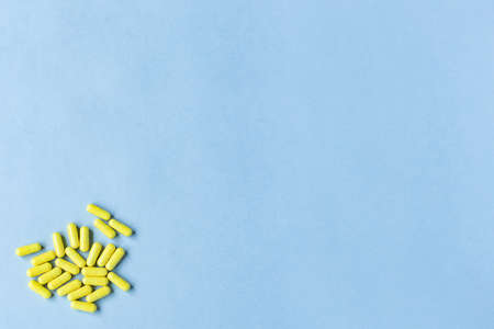 Yellow capsules on a blue background. Omega-3 vitamins. food Supplement. Fish oil in capsules. Free space. copy space. space for text. blurred background. Selective focus. banner. concept of medicine.の写真素材