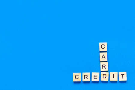 wooden letters credit card on a blue background. banner, free metos, space for text, top view, flat layout, copy space. classic blue colorの写真素材