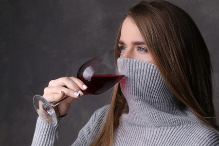 Girl with covered face drinking wine, girl with wineglass, high fashion look, beautiful girl, blonde girl, isolated, model in studio, long hair, close up, gray backgroundの写真素材