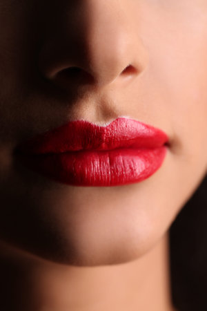 Big red lips, make-up details, passionate red lips, kiss, face in shadow, beautiful girl, model in...