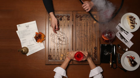 People playing domino. gambling, board games, intelligence match, smoking cigarettes, tea on the...