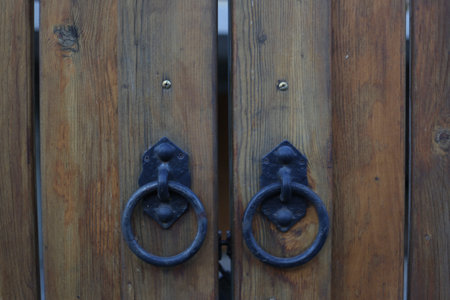 Antique door knockers, concept for design and decoration, brown wooden construction, wood background, close upの写真素材