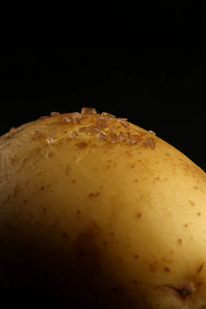 Potato with salt on black background. Close upの写真素材