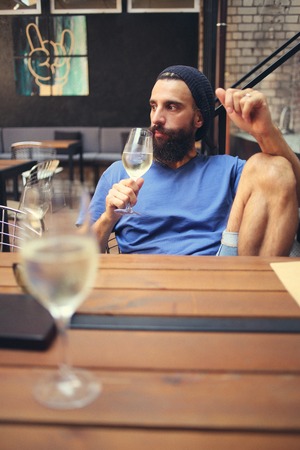 Pensive man holding glass of wineの写真素材