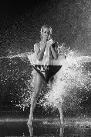 Lady with black liquid in water slashes. Black and white. Photographie retoucheeの写真素材