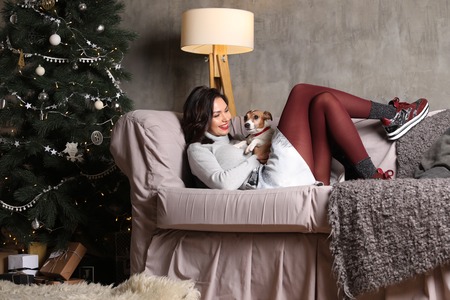 Lady lying on the sofa with a puppy. Photographie retoucheeの写真素材