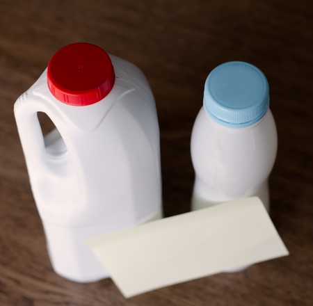 Plastic bottles with paper sticker without text  standing on the wooden table at home in the daylightの写真素材