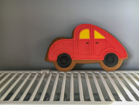 Close-up of red gingerbread car standing on the white metallic radiator like on roadの写真素材