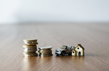 Real estate mortgage concept with small plastic house car and coinsの写真素材