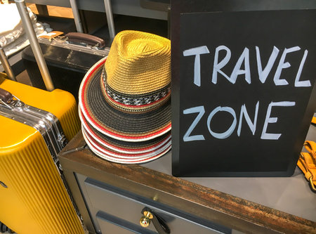 two luggages, hats and plate with text TRAVEL ZONE
