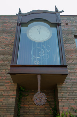 Big outside clock with visible mechanism and moon and sun wooden carved figure. Torun, Poland