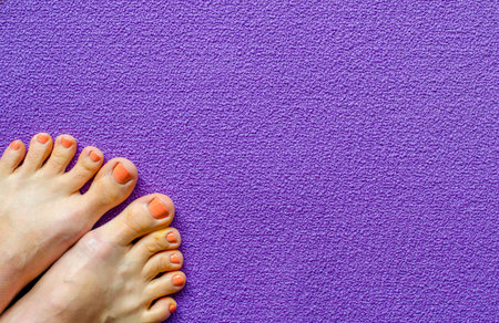 Woman's foot in the corner of yoga mat. Top view