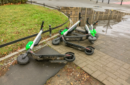 An abandoned dirty Lime scooters lie on the ground of a street in Wroclaw, Poland.の写真素材