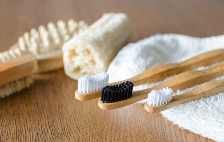 Three Bamboo toothbrushes with towel and eco. Natural background. Loofah, brushes on the backgroundの写真素材