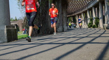 Few women in t-shirts with numbers. Marathon in the park in spring. Wroclaw, Poland - April 7, 2019