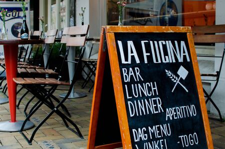 Pizza restaurant "La fucina", Javastraat street, Amsterdam, Netherlands. View of advertising board. Table and chairs.のeditorial素材
