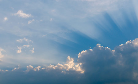 Optimistic sunset rays behind the clouds. Glow in the sky. Symbol of light. Beautiful scene of...