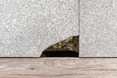 Close-up top view shot of break grunge granite surface floor at corner with dirty deep stone in hole...