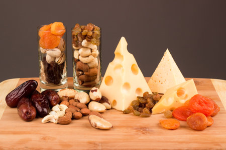 Snacks of nuts and dried fruits on a wooden surfaceの写真素材