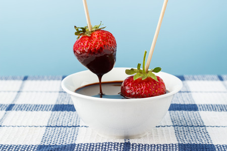 Strawberries and chocolate topping in white plateの写真素材