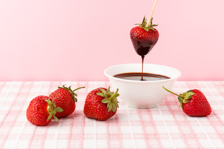 Strawberries and chocolate topping in white plateの写真素材